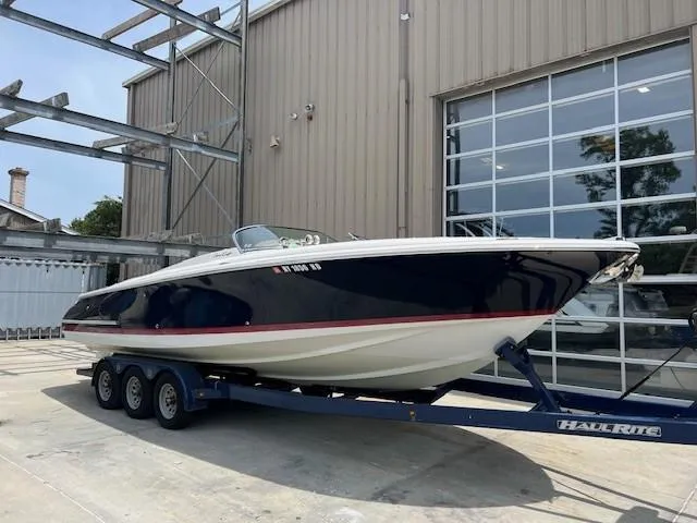 Slide: The Image of 2008 Chris-Craft Launch 28 boat on trailer outside a large garage. - 2