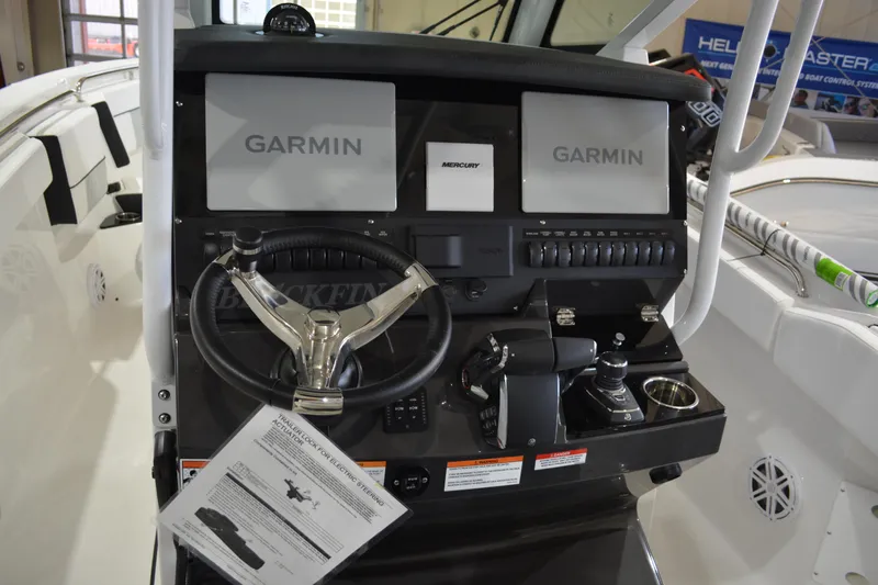Slide: The Image of 2026 Blackfin 272 CC boat dashboard with Garmin displays and steering wheel. - 16