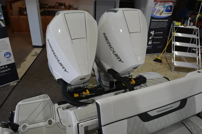 Slide: The Image of 2026 Blackfin 272 CC boat with dual Mercury outboard engines displayed indoors. - 28