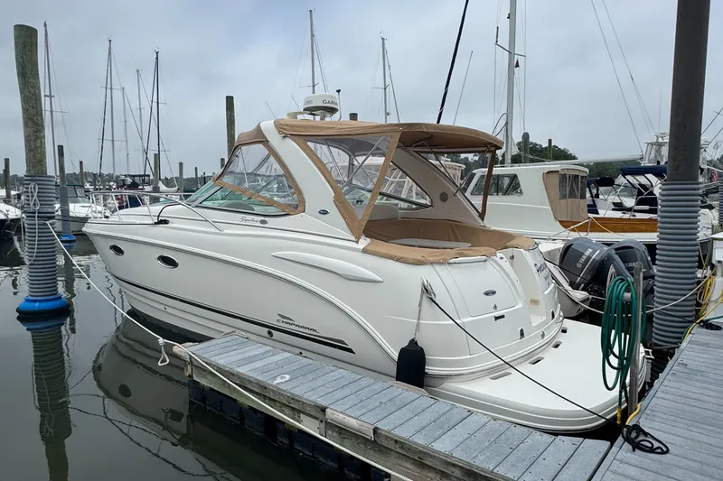 The Image of 2004 Chaparral 330 Signature boat docked at marina, featuring sleek design and beige canopy. - 0