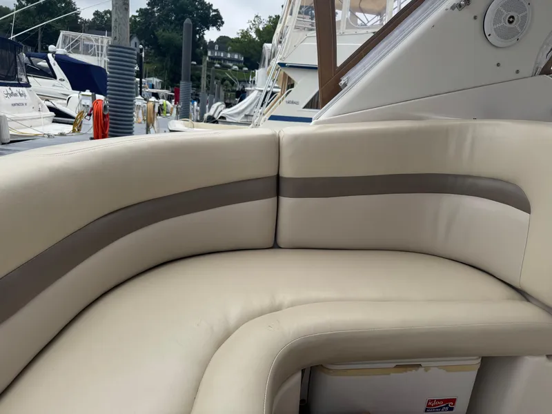 Slide: The Image of 2004 Chaparral 330 Signature boat interior with beige seating at a marina. - 10