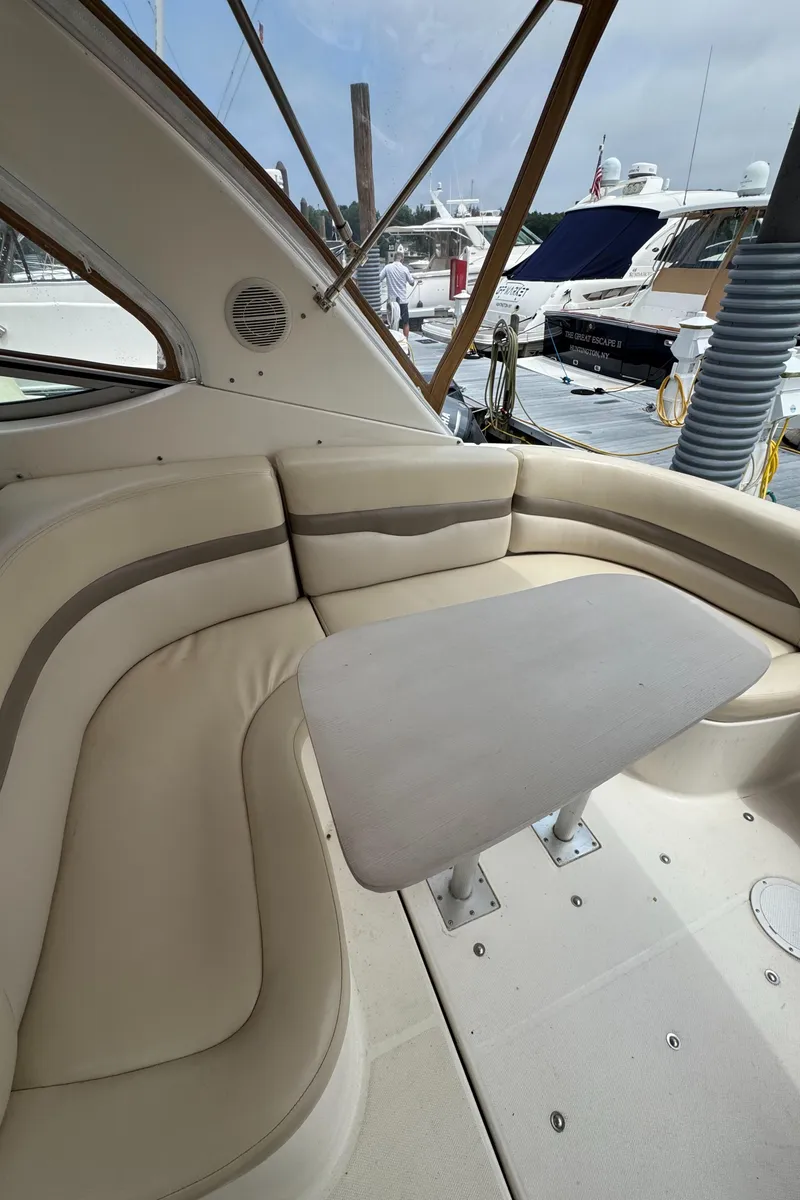 Slide: The Image of 2004 Chaparral 330 Signature boat interior with beige seating and table at marina. - 11
