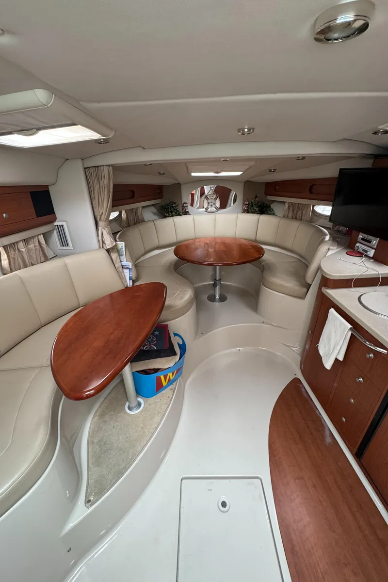 Slide: The Image of 2004 Chaparral 330 Signature yacht interior with curved seating, wooden tables, and modern amenities. - 13