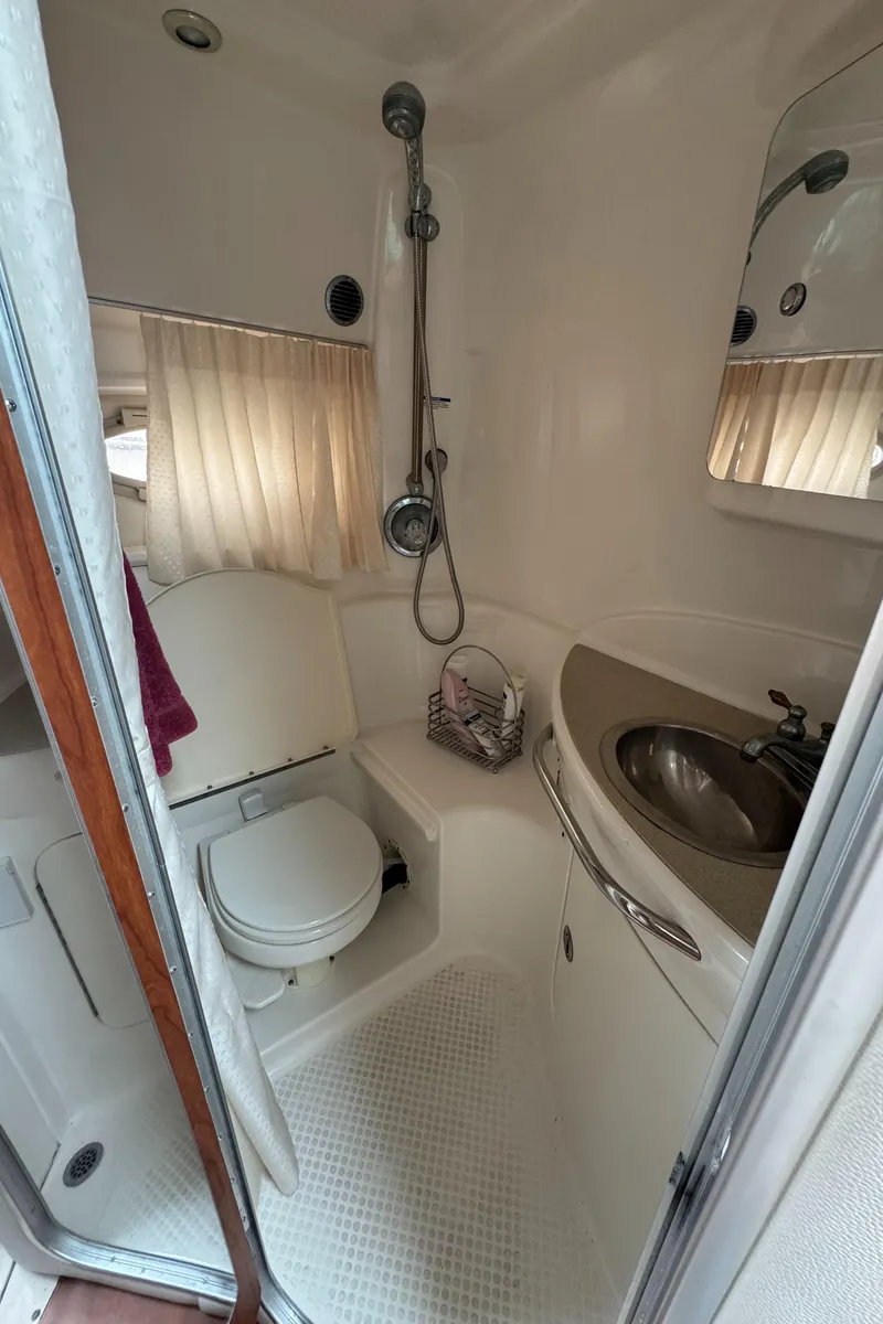 Slide: The Image of 2004 Chaparral 330 Signature boat bathroom with shower, sink, and toilet. - 17