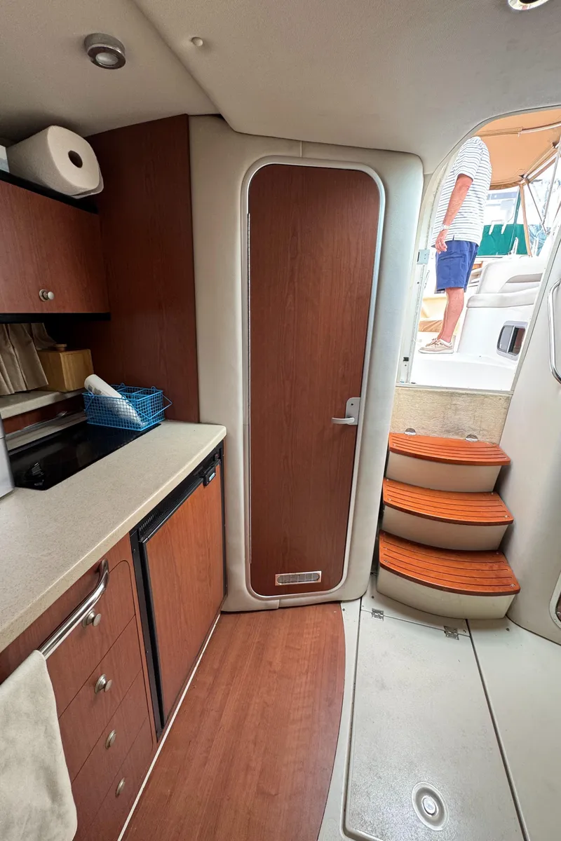 Slide: The Image of 2004 Chaparral 330 Signature yacht interior with kitchenette and stairs to deck. - 21