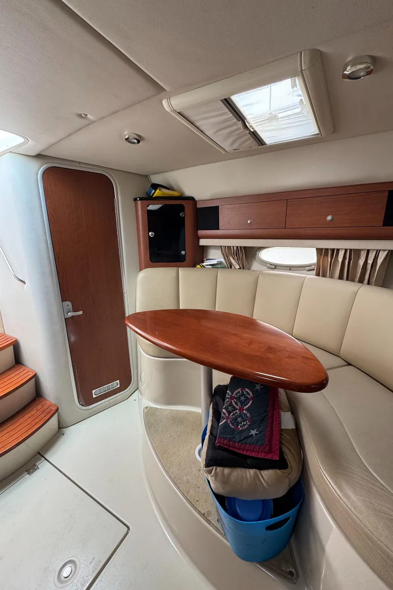 Slide: The Image of 2004 Chaparral 330 Signature cabin interior with seating, table, and storage. - 22