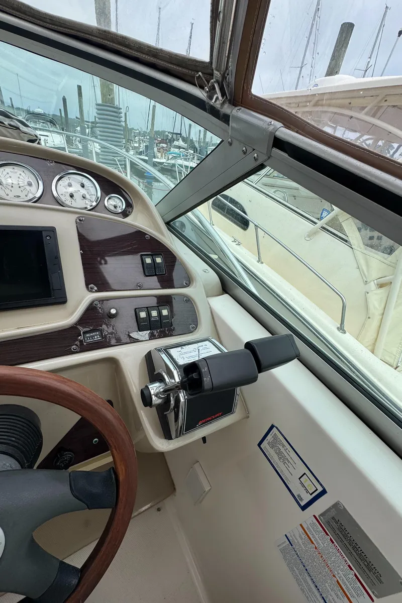 Slide: The Image of 2004 Chaparral 330 Signature boat dashboard with controls and gauges in a marina setting. - 7