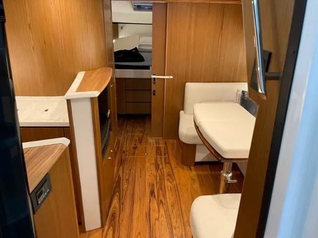 Slide: The Image of Interior of 2022 Tiara Yachts 39 Open, featuring wood finishes and a cozy seating area. - 10