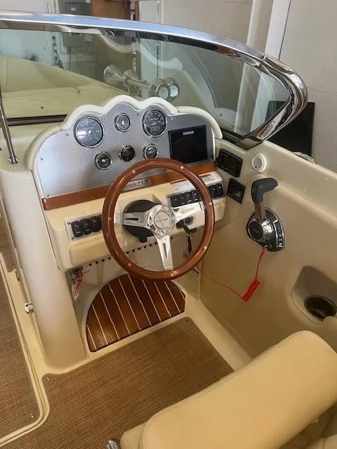 Slide: The Image of 2020 Chris-Craft Launch 27 cockpit with wooden steering wheel and control panel. - 12