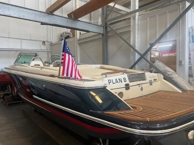 Slide: The Image of 2020 Chris-Craft Launch 27 boat in storage, featuring an American flag and "Plan B" nameplate. - 4