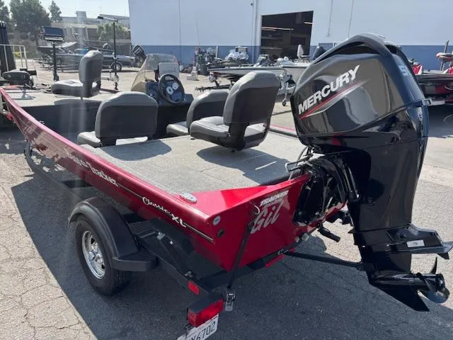 Slide: The Image of 2024 Tracker Bass Tracker Classic XL boat with Mercury engine, parked outdoors. - 5