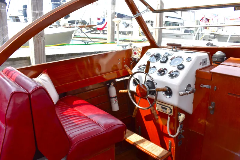Slide: The Image of 1960 Chris-Craft Sea Skiff interior with red seats and classic wooden steering wheel. - 3