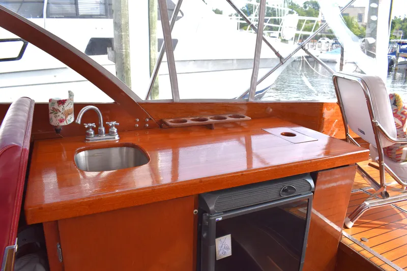 Slide: The Image of 1960 Chris-Craft Sea Skiff interior with wooden counter, sink, and mini fridge. - 7