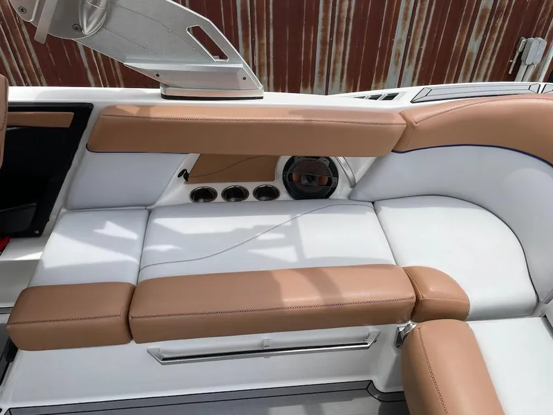 Slide: The Image of 2019 MasterCraft XT23 interior with tan and white seating, featuring built-in speakers. - 17