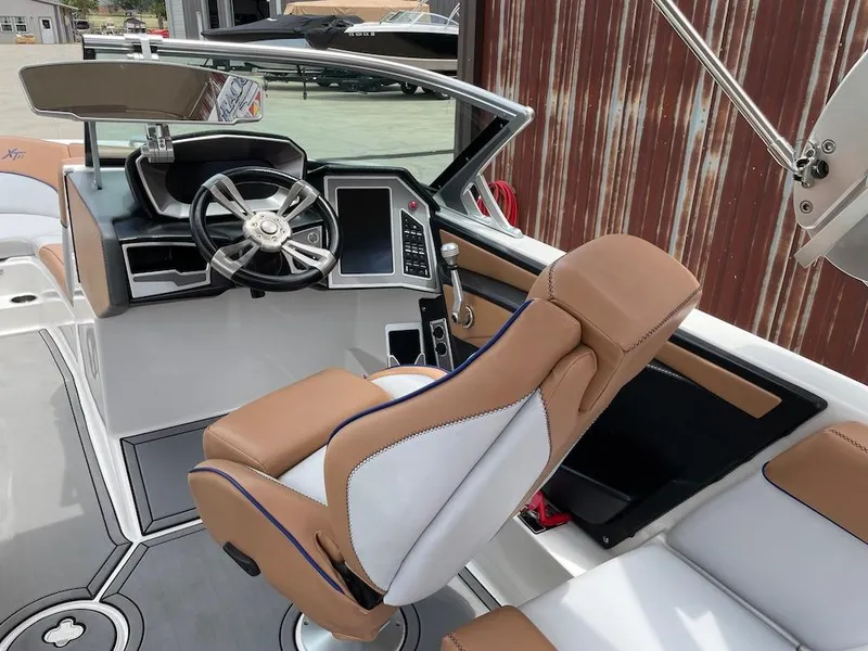 Slide: The Image of 2019 MasterCraft XT23 boat cockpit with tan seats and modern steering controls. - 7