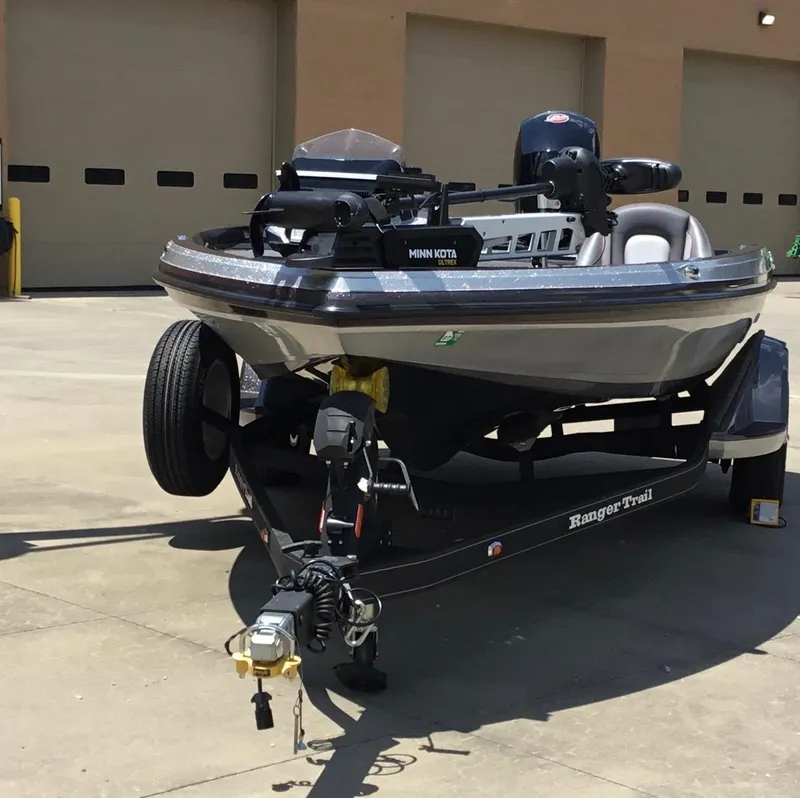 Slide: The Image of 2023 Ranger Z518 boat on trailer, featuring Minn Kota motor, parked outdoors. - 1