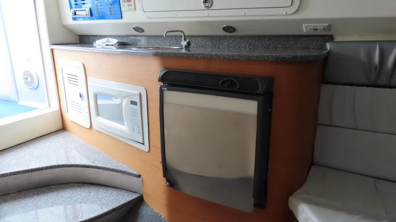 Slide: The Image of 2007 Active Thunder 37 boat interior with kitchenette, featuring microwave and compact fridge. - 22