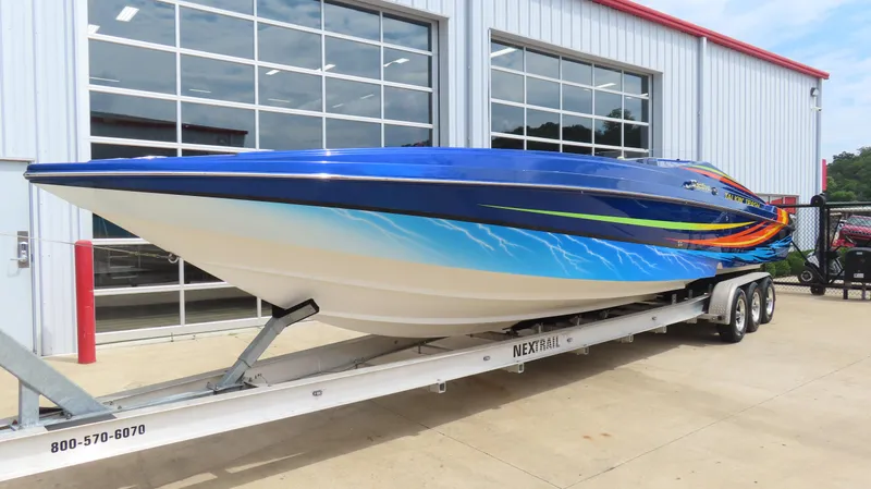 Slide: The Image of 2007 Active Thunder 37 speedboat on trailer, vibrant blue with colorful graphics, parked outside. - 4