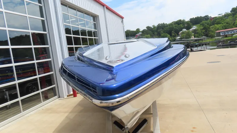 Slide: The Image of 2007 Active Thunder 37 boat with blue hull, displayed outdoors near a garage. - 5