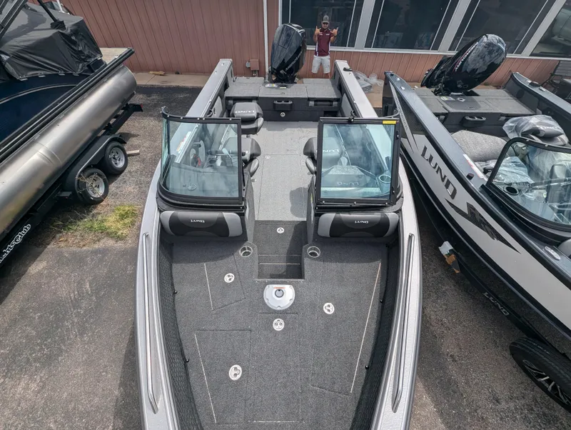 Slide: The Image of Lund 1975 Tyee 2025 model boat with open cockpit and windshield, parked outdoors. - 10
