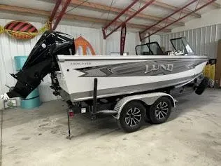 Slide: The Image of 2025 Lund 1975 Tyee boat in garage, on trailer, with outboard motor. - 17