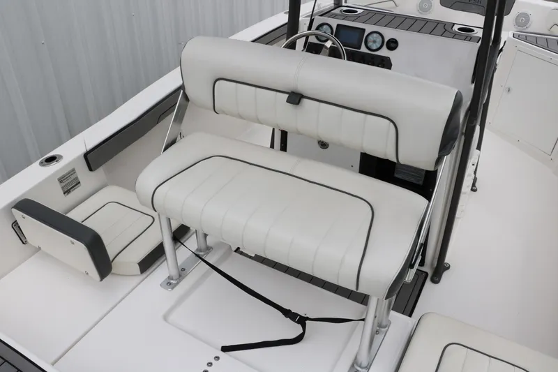 Slide: The Image of 2019 Yamaha Boats 210 FSH Sport interior with white seating and steering console. - 10