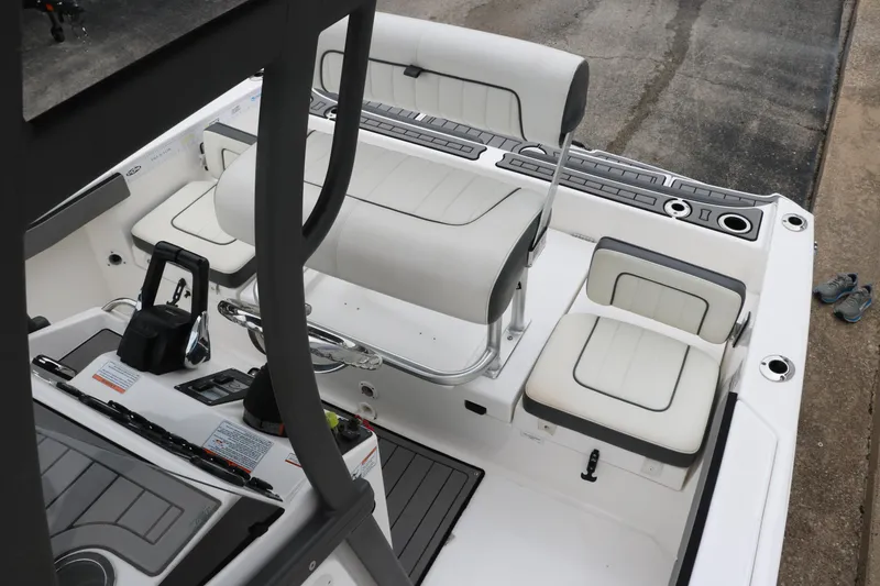 Slide: The Image of 2019 Yamaha Boats 210 FSH Sport interior with white seating and control panel. - 19