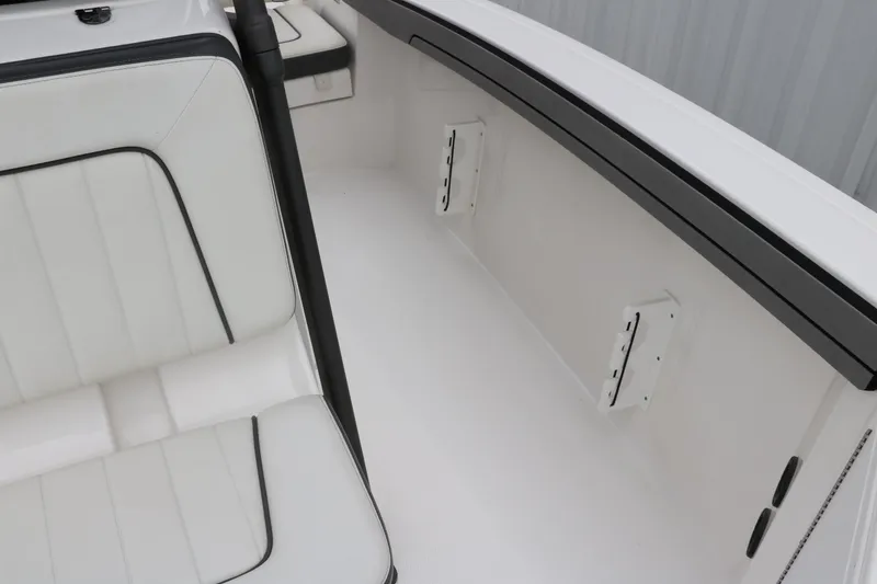 Slide: The Image of 2019 Yamaha Boats 210 FSH Sport interior seating detail, featuring white upholstery and sleek design. - 22