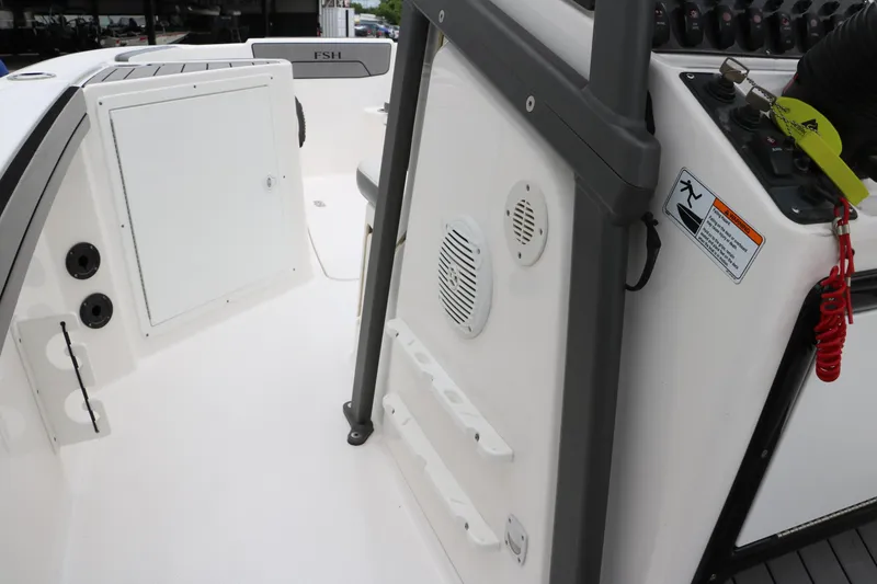 Slide: The Image of 2019 Yamaha Boats 210 FSH Sport interior, featuring control panel and storage compartments. - 25