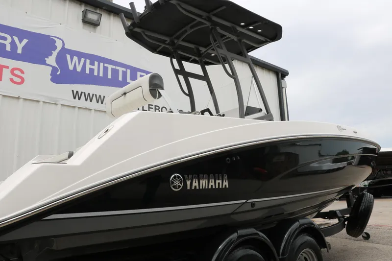 Slide: The Image of 2019 Yamaha Boats 210 FSH Sport, black and white, on trailer, side view. - 29