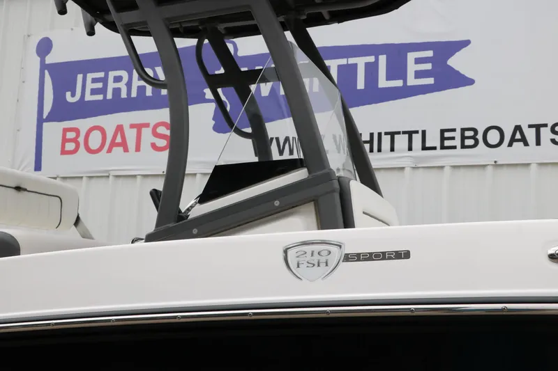 Slide: The Image of 2019 Yamaha Boats 210 FSH Sport displayed at dealership with signage in background. - 30