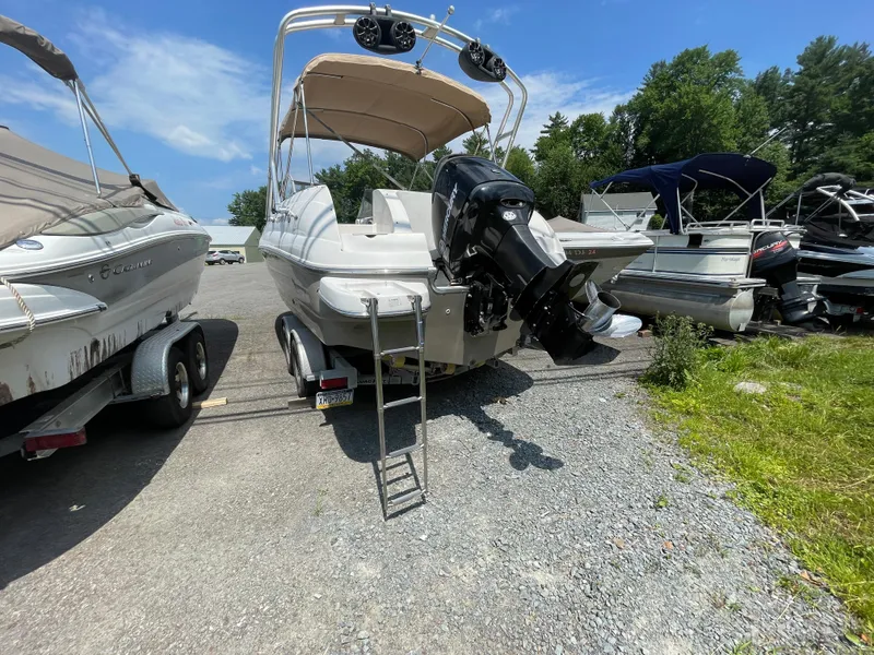 Slide: The Image of 2007 Starcraft 2410 OB Limited boat on trailer, parked outdoors under clear sky. - 10