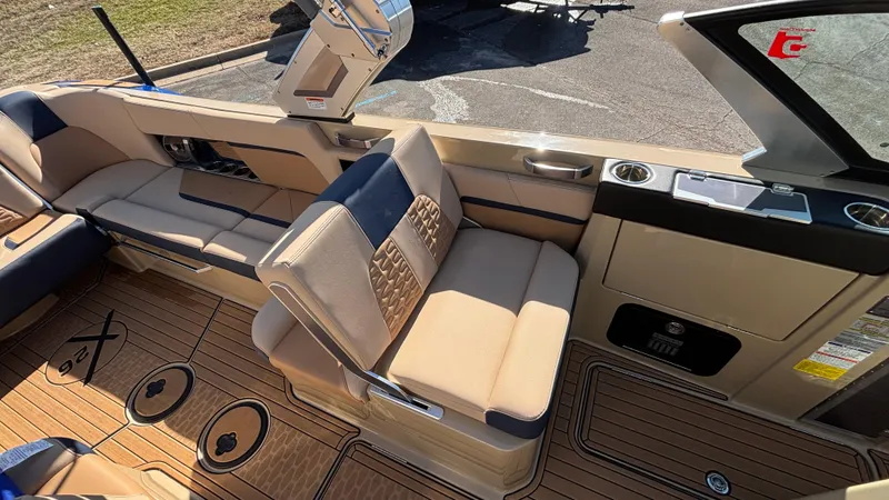 Slide: The Image of 2022 MasterCraft X26 boat interior with beige seating and teak flooring. - 13