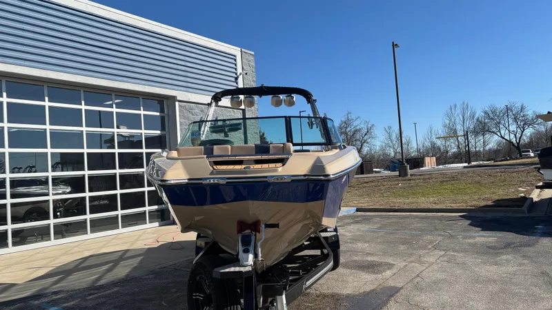 Slide: The Image of 2022 MasterCraft X26 boat parked outside a building on a sunny day. - 19