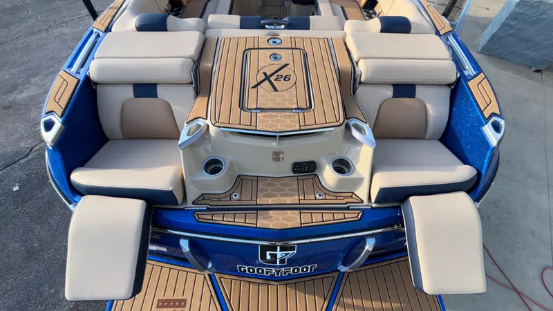 Slide: The Image of 2022 MasterCraft X26 boat interior with cushioned seating and teak-style flooring. - 22