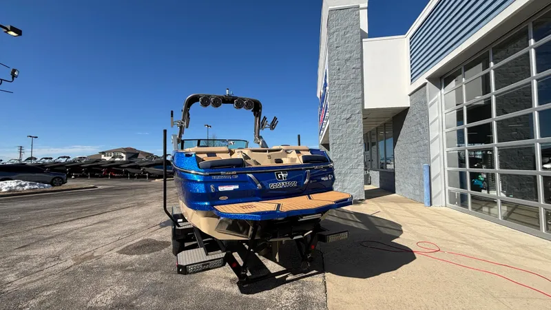 Slide: The Image of 2022 MasterCraft X26 boat in blue, parked outside a dealership under clear skies. - 3