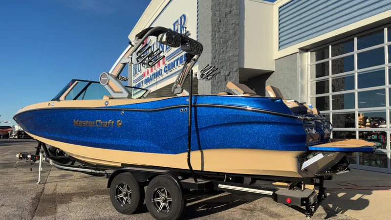 Slide: The Image of 2022 MasterCraft X26 boat in blue and beige, parked outside a boating center. - 37