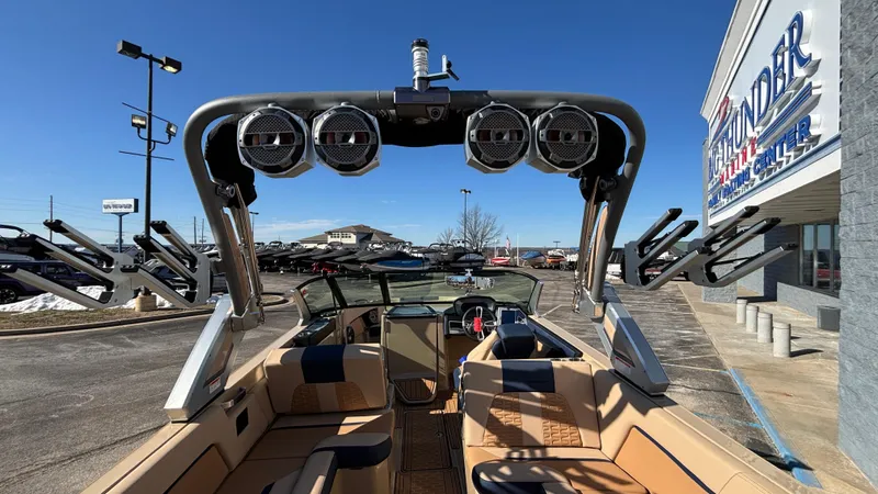 Slide: The Image of 2022 MasterCraft X26 boat with speakers, parked at a dealership under clear blue skies. - 9