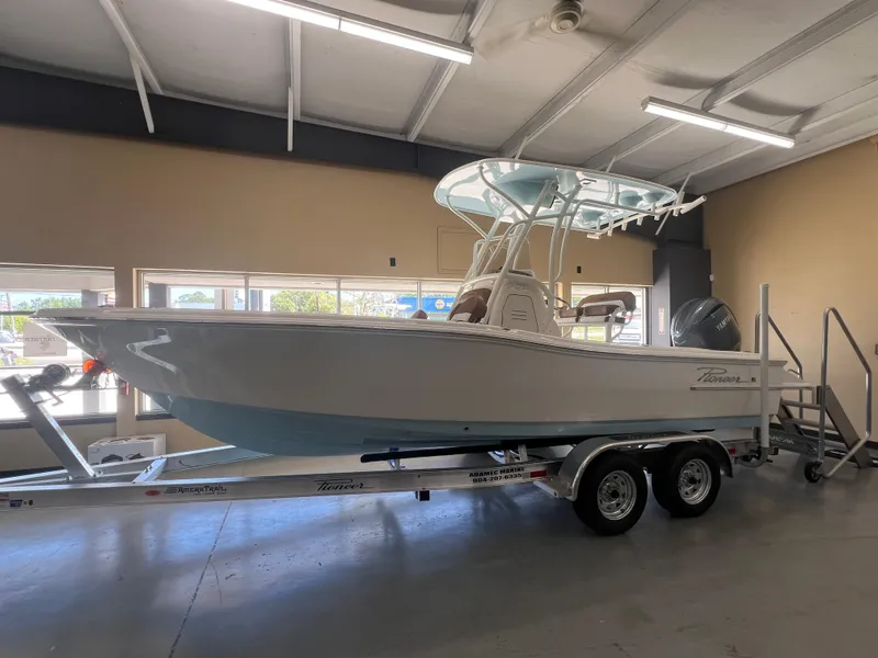 The Image of 2026 Pioneer 220 Bay Sport boat on trailer in showroom, side view. - 1