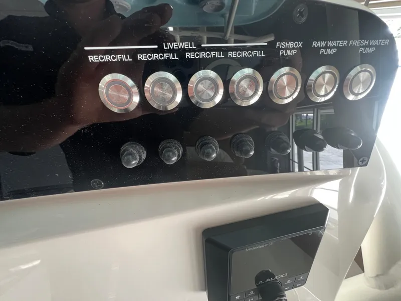 Slide: The Image of Control panel of 2026 Pioneer 220 Bay Sport boat with various pump switches. - 14