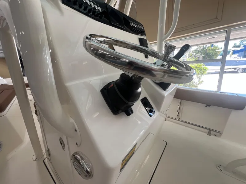 Slide: The Image of 2026 Pioneer 220 Bay Sport boat steering console with chrome wheel and controls. - 16