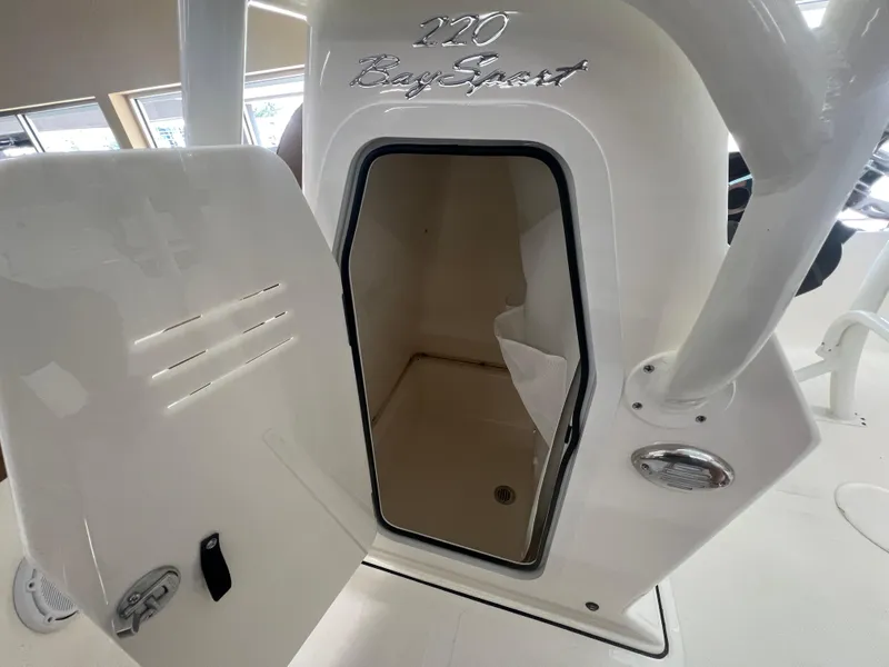 Slide: The Image of 2026 Pioneer 220 Bay Sport boat storage compartment with open door. - 17