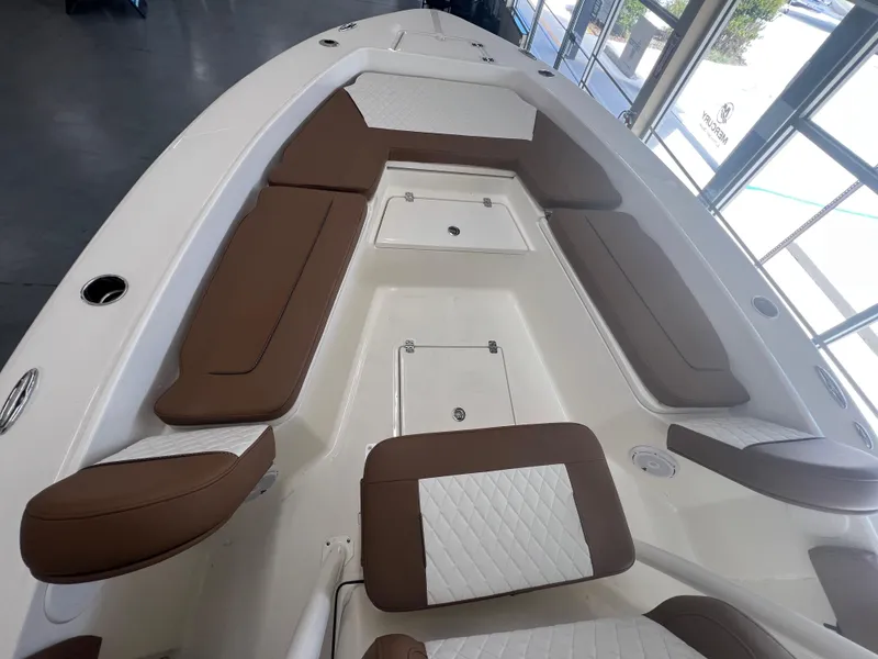 Slide: The Image of 2026 Pioneer 220 Bay Sport boat interior with brown and white cushioned seating. - 18