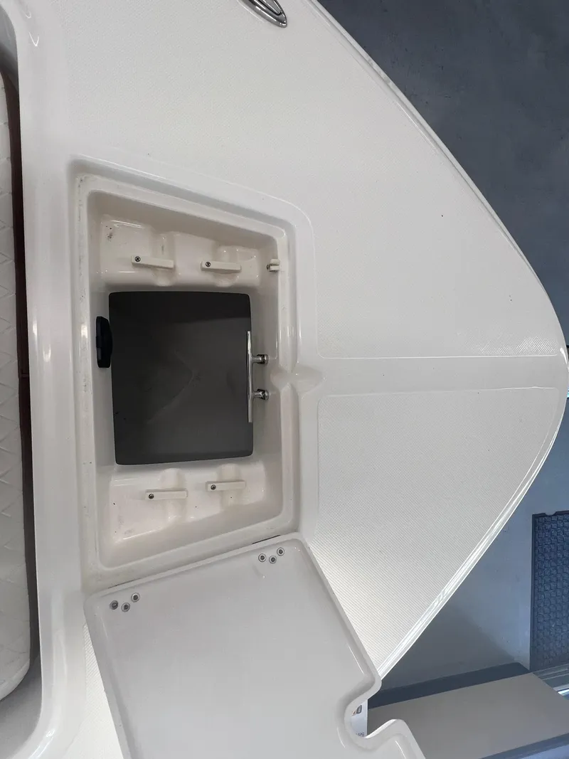 Slide: The Image of 2026 Pioneer 220 Bay Sport boat deck with storage compartment open. - 24