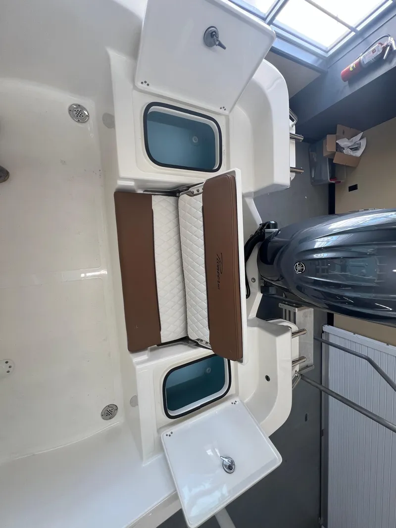 Slide: The Image of 2026 Pioneer 220 Bay Sport boat interior with storage compartments and motor. - 6