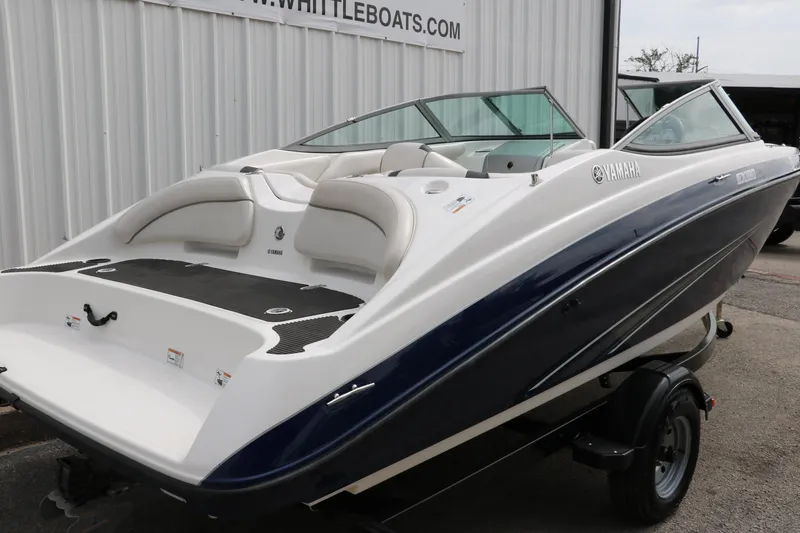Slide: The Image of 2014 Yamaha SX190 boat with sleek design on trailer, parked near a building. - 3