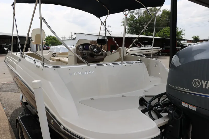 Slide: The Image of 2015 Stingray 192 SC boat with Yamaha outboard motor, parked in a marina. - 11