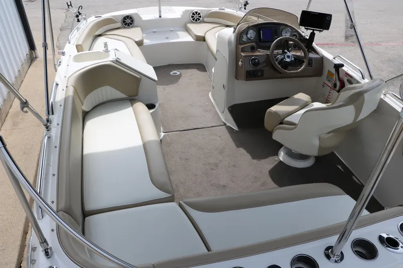 Slide: The Image of 2015 Stingray 192 SC boat interior with beige seating and modern dashboard. - 14