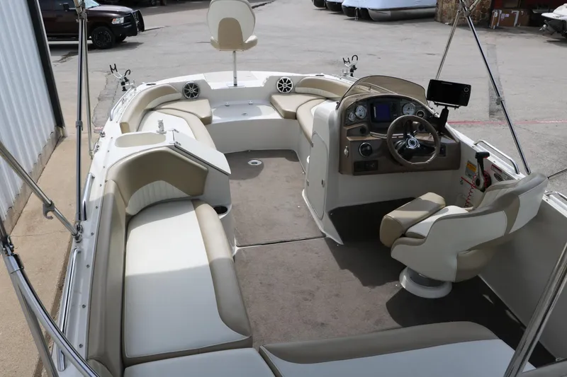 Slide: The Image of 2015 Stingray 192 SC boat interior with beige seating and modern dashboard. - 15