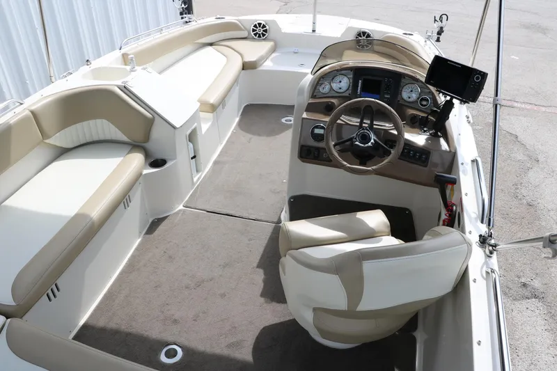 Slide: The Image of 2015 Stingray 192 SC boat interior with beige seating and modern dashboard. - 18